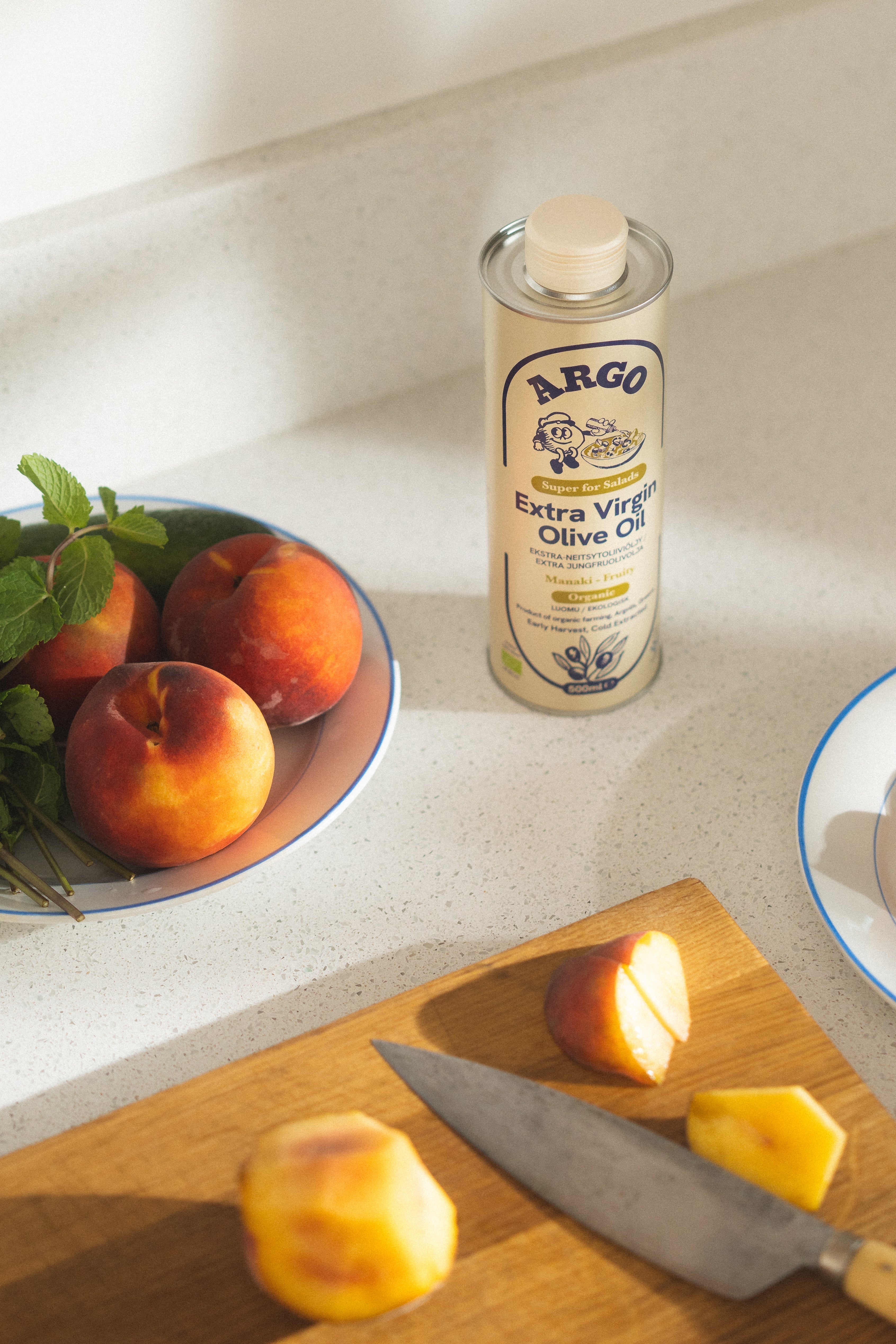 The Argo Manaki tin on a laid table with cheese, bread and lemon.